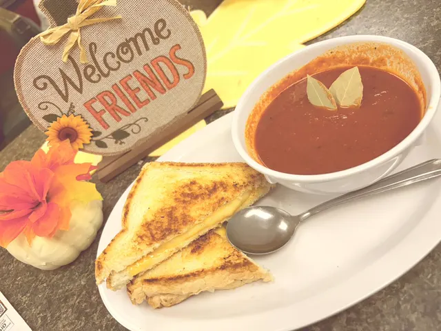 Grilled cheese and a bowl of tomato soup next to a Welcome Friends sign